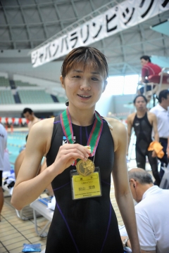 100m背泳ぎで優勝し、メダルを首にかける秋山里奈